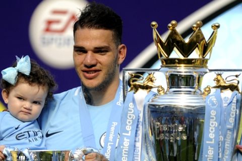 Manchester City's goalkeeper Ederson Moraes poses with his daughter Yasmin during celebrations for winning the English Premier League after the soccer match between Manchester City and Huddersfield Town at Etihad stadium in Manchester, England, Sunday, May 6, 2018. (AP Photo/Rui Vieira)