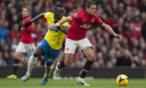 Manchester United's Javier Hernandez keeps the ball from Newcastle's Cheik Ismael Tiote during their English Premier League soccer match at Old Trafford Stadium, Manchester, England, Saturday Dec. 7, 2013. (AP Photo/Jon Super)