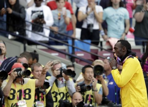 Jamaica's Usain Bolt kisses his bronze medal during the ceremony for the men's 100-meter final during the World Athletics Championships in London Sunday, Aug. 6, 2017. (AP Photo/Matthias Schrader)