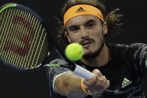 Stefanos Tsitsipas of Greece hits a return shot while competing against Dominic Thiem of Austria in the men's final at the China Open tennis tournament in Beijing, Sunday, Oct. 6, 2019. (AP Photo/Mark Schiefelbein)