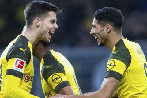 Achraf Hakimi (derecha) y Julian Weigl festejan el primer gol del Borussia Dortmund en el partido ante Hannover 96 por la Bundesliga, en Dortmund, Alemania, el sábado 26 de enero de 2019. (Guido Kirchner/dpa via AP)