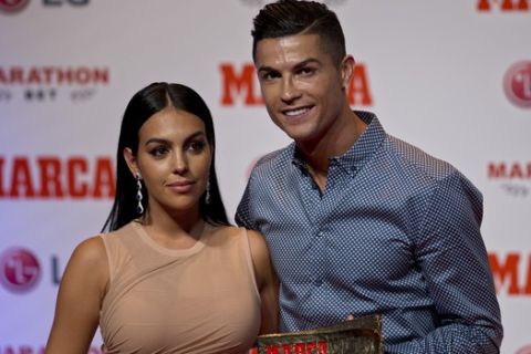 Juventus soccer player Cristiano Ronaldo poses with his partner, model Georgina Rodriguez after receiving the Lifetime Achievement award given by the Spanish sports paper 'Marca', in Madrid, Spain, Monday, July 29, 2019. (AP Photo/Paul White)