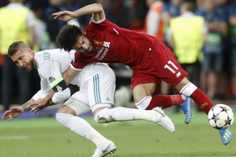 FILE - In this Saturday, May 26, 2018 file photo Real Madrid's Sergio Ramos, left, fouls Liverpool's Mohamed Salah during the Champions League Final soccer match between Real Madrid and Liverpool at the Olimpiyskiy Stadium in Kiev, Ukraine. Sergio Ramos isn't taking blame for the challenge that ended hurting Egypt star Mohamed Salah in the Champions League final. Salah left the field in tears after injuring his left shoulder in a tussle with Ramos with the score 0-0 in the first half. (AP Photo/Efrem Lukatsky, File)