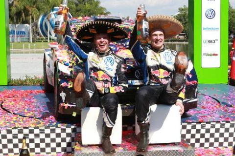Volkswagen Motorsport team Jari Matti Latvala, right, and his co-pilot, Miikka Antila, both from Finland, celebrate hold up beer bottles as they celebrate wearing sombreros and boots after they won the WRC Rally in Guanajuato, Mexico, Sunday March 6, 2016. (AP Photo/Mario Armas)