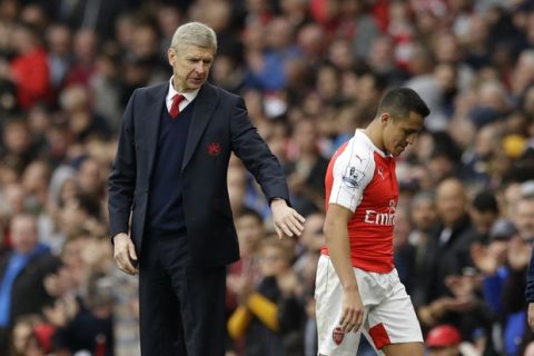 Arsenal's French manager Arsene Wenger pats Alexis Sanchez as he leaves the pitch after being substituted during the English Premier League soccer match between Arsenal and Watford at the Emirates Stadium in London, Saturday, April 2, 2016.  (AP Photo/Matt Dunham)