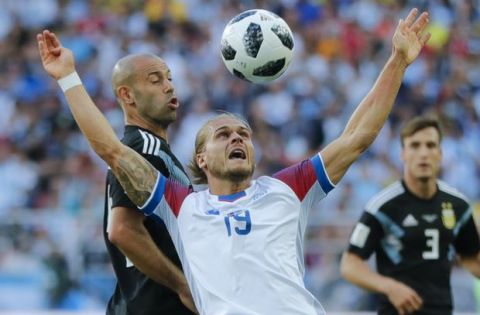 Iceland's Rurik Gislason, right, challenges for the ball with Argentina's Javier Mascherano during the group D match between Argentina and Iceland at the 2018 soccer World Cup in the Spartak Stadium in Moscow, Russia, Saturday, June 16, 2018. (AP Photo/Ricardo Mazalan)