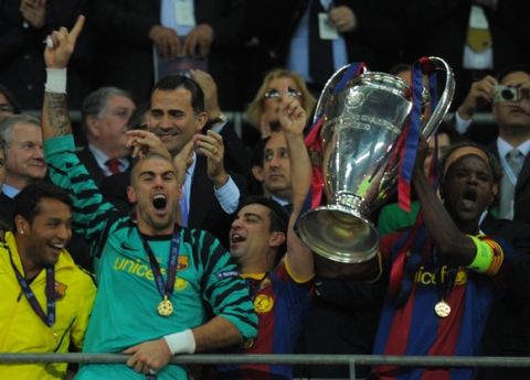 Barcelona's Spanish goalkeeper Victor Valdes (L) and Barcelona's French defender Eric Abidal (R) celebrate with the trophy at the end of the UEFA Champions League final football match FC Barcelona vs. Manchester United, on May 28, 2011 at Wembley stadium in London.Barcelona won 3 to 1. AFP PHOTO / LLUIS GENE
