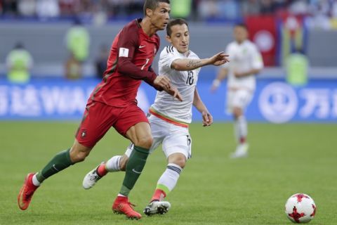 Portugal's Cristiano Ronaldo, left, and Mexico's Andres Guardado go for the ball during the Confederations Cup, Group A soccer match between Portugal and Mexico, at the Kazan Arena, Russia, Sunday, June 18, 2017. (AP Photo/Thanassis Stavrakis)