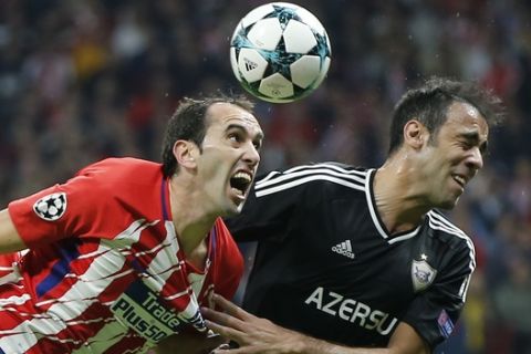 Atletico's Diego Godin, left and Qarabag's Elvin Ismayilov jump for the ball during a Group C Champions League soccer match between Atletico Madrid and Qarabag at the Metropolitano stadium in Madrid, Spain, Tuesday, Oct. 31, 2017. (AP Photo/Paul White)
