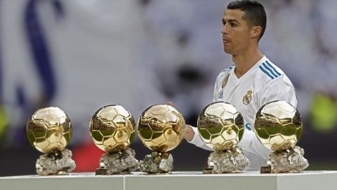 Real Madrid's Cristiano Ronaldo poses for the media with his five Golden Ball trophies prior the Spanish La Liga soccer match between Real Madrid and Sevilla at the Santiago Bernabeu stadium in Madrid, Saturday, Dec. 9, 2017. (AP Photo/Francisco Seco)