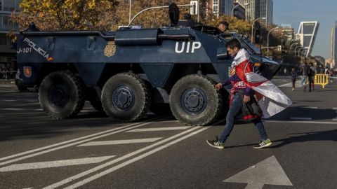 A River Plate supporter walks past an Armored Personnel Carrier ahead of the Copa Libertadores Final between River Plate and Boca Juniors in Madrid, Sunday, Dec. 9, 2018. Tens of thousands of Boca and River fans are in the city for the "superclasico" at Santiago Bernabeu Stadium on Sunday. (AP Photo/Olmo Calvo)