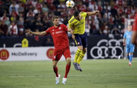 Bayern Munich' Thomas Mueller, left, is defended by Arsenal's Sokratis Papastathopoulos during the first half of an International Champions Cup soccer match Wednesday, July 17, 2019, in Carson, Calif. (AP Photo/Marcio Jose Sanchez)