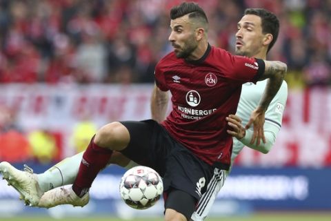 Nuremberg's Mikael Ishak, left, challenges for the ball with Bayern's Mats Hummels during the German Bundesliga soccer match between 1. FC Nuremberg and FC Bayern Munich in Nuremberg, Germany, Sunday, April 28, 2019. (AP Photo/Matthias Schrader)