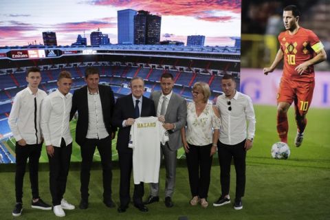 Belgium forward Eden Hazard, third from right, holds his new shirt with Real Madrid's President Florentino Perez, fourth from right, while poses with family members during his official presentation after signing for Real Madrid at the Santiago Bernabeu stadium in Madrid, Spain, Thursday, June 13, 2019. Real Madrid announced last week that it had acquired the 28-year-old Belgian playmaker from Chelsea for a reported fee of around 100 million euros ($113 million) plus variables, making him the club's most expensive signing ever. (AP Photo/Manu Fernandez)