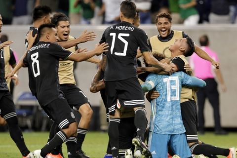 Mexico players swarm goalkeeper Guillermo Ochoa (13) after he stopped the penalty kick by Costa Rica defender Keysher Fuller to give the team the win on penalty kicks during the shootout after the the a 1-1 tie in a CONCACAF Gold Cup soccer quarterfinal Saturday, June 29, 2019, in Houston. (AP Photo/Michael Wyke)