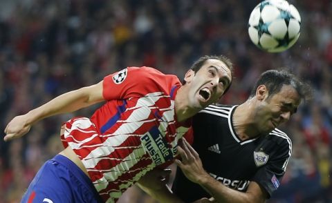 Atletico's Diego Godin, left and Qarabag's Elvin Ismayilov jump for the ball during a Group C Champions League soccer match between Atletico Madrid and Qarabag at the Metropolitano stadium in Madrid, Spain, Tuesday, Oct. 31, 2017. (AP Photo/Paul White)