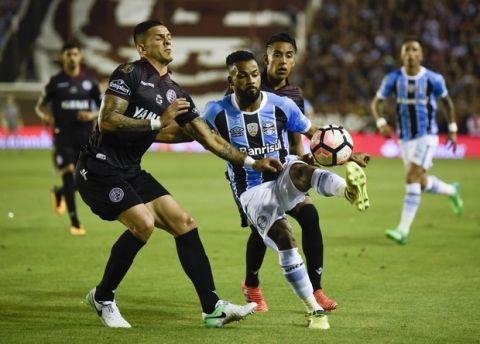 Fernandinho of Brazil's Gremio, center, fights for the ball with Luis Herrera Argentina's Lanus during the final Copa Libertadores championship soccer match in Buenos Aires, Argentina, Wednesday, Nov. 29, 2017. (AP Photo/Gustavo Garello)