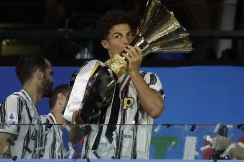 Juventus' Cristiano Ronaldo kisses the trophy as Juventus players celebrate winning an unprecedented ninth consecutive Italian Serie A soccer title, at the end of the a Serie A soccer match between Juventus and Roma, at the Allianz stadium in Turin, Italy, Saturday, Aug.1, 2020. (AP Photo/Luca Bruno)