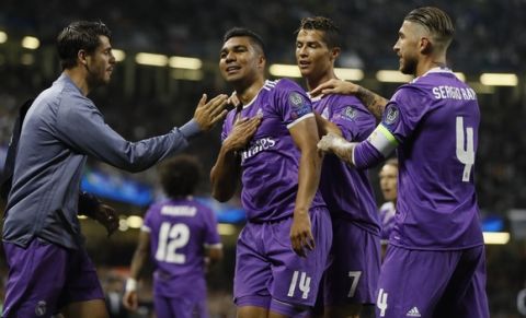 Real Madrid's Casemiro, left, celebrate with his teammates Cristiano Ronaldo, center and Sergio Ramos during the Champions League final soccer match between Juventus and Real Madrid at the Millennium Stadium in Cardiff, Wales, Saturday June 3, 2017. (AP Photo/Kirsty Wigglesworth)