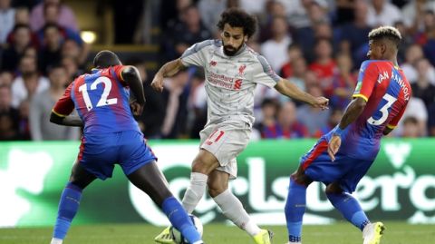 Liverpool's Mohamed Salah, center, duels for the ball with Crystal Palace's Mamadou Sakho, left, and Patrick van Aanholt during the English Premier League soccer match between Crystal Palace and Liverpool at Selhurst Park stadium in London, Monday, Aug. 20, 2018. (AP Photo/Kirsty Wigglesworth)