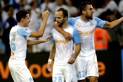 Marseille's Valere Germain, center, celebrates with teammates Florian Thauvin, left, and Kevin Strootman, after scoring scores his side's third goal during the League One soccer match between Marseille and Strasbourg at the Velodrome stadium, in Marseille, southern France, Wednesday, Sept. 26, 2018. (AP Photo/Claude Paris)