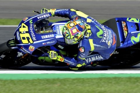 FILE -- In this Aug. 27, 2017 file photo, Italy's Valentino Rossi of Movistar Yamaha steers his bike during the Moto GP race at the British Grand Prix at Silverstone, England. Six-time MotoGP champion Rossi has reportedly broken his right leg in a training accident in Italy. According to Italian sports daily Gazzetta dello Sport, Rossi fell during enduro training and fractured his tibia and fibula. (AP Photo/Rui Vieira)