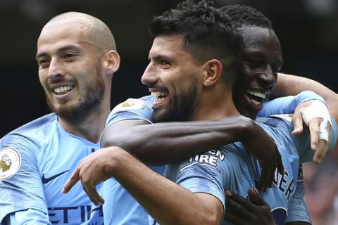 Manchester City's Sergio Aguero celebrates scoring his side's third goal of the game with David Silva, left, and Benjamin Mendy during the English Premier League soccer match between Manchester City and Huddersfield Town at the Etihad Stadium in Manchester, England, Sunday, Aug. 19, 2018. (AP Photo/Dave Thompson)