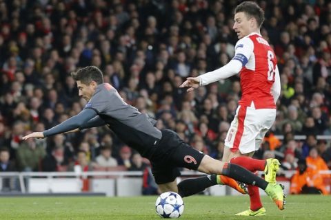 Arsenal's Laurent Koscielny, right, fouls Bayern's Robert Lewandowski to concede a penalty during the Champions League round of 16 second leg soccer match between Arsenal and Bayern Munich at the Emirates Stadium in London, Tuesday, March 7, 2017. (AP Photo/Frank Augstein)