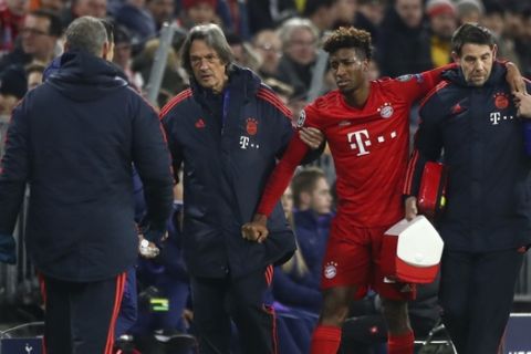 Bayern's Kingsley Coman is helped off the pitch after suffering an injury during the Champions League group B soccer match between Bayern Munich and Tottenham Hotspur at the Allianz Arena stadium, in Munich, Wednesday, Dec. 11, 2019. (AP Photo/Matthias Schrader)