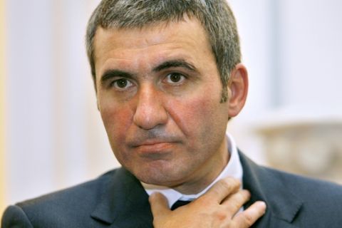 Former Romanian soccer star Gheorghe Hagi adjusts his collar, in Bucharest Romania, Monday June 25 2007, during the first press conference after becoming the new coach of first division club Steaua Bucharest. Hagi signed a three-year contract with the Bucharest club.(AP Photo/Vadim Ghirda)