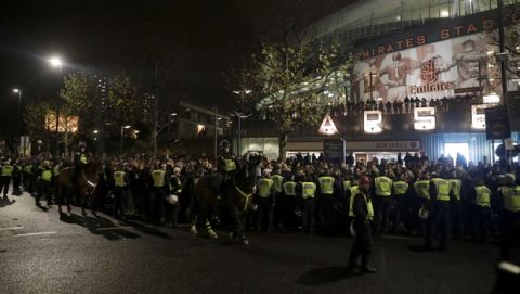 Police form a line at the edge of the road in front of Eintracht Frankfurt fans, who are not allowed in the stadium after crowd trouble at their game against Vitoria Guimaraes in October, before the Europa League Group F soccer match between Arsenal and Eintracht Frankfurt outside the Emirates Stadium, in London, Thursday, Nov. 28, 2019. (AP Photo/Matt Dunham)
