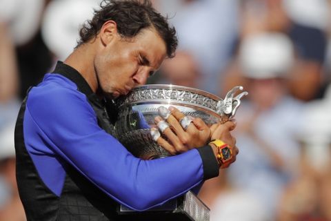 Spain's Rafael Nadal kisses the trophy as he celebrates winning his tenth French Open title against Switzerland's Stan Wawrinka in three sets, 6-2, 6-3, 6-1, during their men's final match of the French Open tennis tournament at the Roland Garros stadium, in Paris, France, Sunday, June 11, 2017. (AP Photo/Christophe Ena)