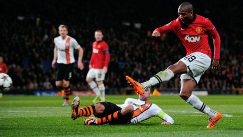 Manchester United's English midfielder Ashley Young (R) fends off a challenge by Shakhtar Donetsk's Croatian defender Darijo Srna (2-R) during the UEFA Champions League football match between Manchester United and Shakhtar Donetsk at Old Trafford in Manchester, north west England on December 10, 2013. AFP PHOTO/ANDREW YATES        (Photo credit should read ANDREW YATES/AFP/Getty Images)