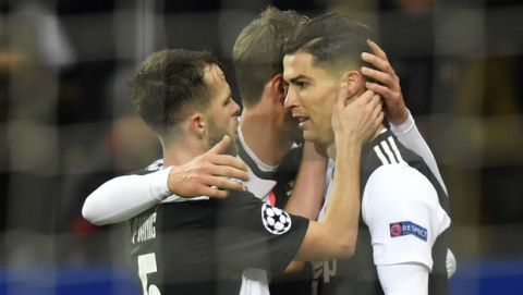 Juventus' Cristiano Ronaldo, right, celebrates with his teammates after scores his side's opening goal during the Champions League Group D soccer match between Bayer Leverkusen and Juventus at the BayArena in Leverkusen, Germany, Wednesday, Dec. 11, 2019. (AP Photo/Martin Meissner)