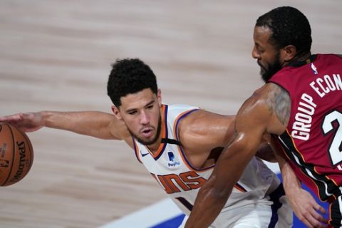 Phoenix Suns' Devin Booker (1) looks to get around Miami Heat's Andre Iguodala (28) during the second half of an NBA basketball game, Saturday, Aug. 8, 2020, in Lake Buena Vista, Fla. The Suns won 119-112. (AP Photo/Ashley Landis, Pool)