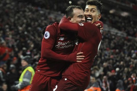 Liverpool's Xherdan Shaqiri, left, celebrates with his teammate Roberto Firmino after scoring his side's third goal during the English Premier League soccer match between Liverpool and Manchester United at Anfield in Liverpool, England, Sunday, Dec. 16, 2018. (AP Photo/Rui Vieira)