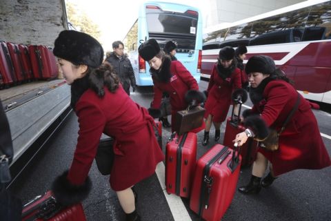 North Korean cheering squads carry suitcases upon their arrival at the Korean-transit office near the Demilitarized Zone in Paju, South Korea, Wednesday, Feb. 7, 2018. A North Korean delegation, including members of a state-trained cheering group, arrived in South Korea on Wednesday for the Pyeongchang Winter Olympics. (AP Photo/Ahn Young-joon. Pool)