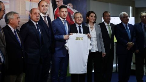 Serbia forward Luka Jovic, center left, holds his new shirt with Real Madrid's President Florentino Perez during his official presentation after signing for Real Madrid at the Santiago Bernabeu stadium in Madrid, Spain, Wednesday, June 12, 2019. The 21-year-old Jovic, who scored 17 goals in 32 Bundesliga games for Eintracht Frankfurt last season, agreed to a six-year deal with Madrid. (AP Photo/Manu Fernandez)