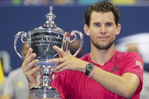 Dominic Thiem, of Austria, holds up the championship trophy after defeating Alexander Zverev, of Germany, in the men's singles final of the US Open tennis championships, Sunday, Sept. 13, 2020, in New York. (AP Photo/Frank Franklin II)