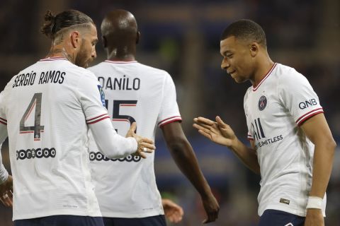 PSG's Kylian Mbappe, right, celebrates with teammate PSG's Sergio Ramos after scoring his side's opening goal during the French League One soccer match between Strasbourg and Paris Saint-Germain at Stade de la Meinau stadium in Strasbourg, eastern France, Friday, April 29, 2022. (AP Photo/Jean-Francois Badias)