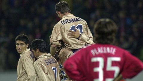 Argentinian Diego Placente, right, of Leverkusen, looks on while the players of FC Barcelona celebrate Marc Overmars' (11)  goal during the Champions League Group A match Bayer Leverkusen against FC Barcelona at the BayArena stadium in Leverkusen, Germany, Wednesday, Nov. 27,  2002. (AP Photo/Hermann J. Knippertz)