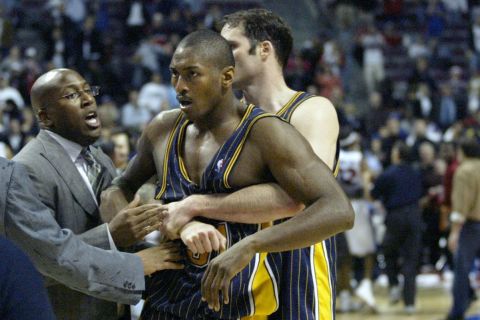 FILE - Indiana Pacers' Ron Artest is restrained by Austin Croshere before being escorted off the court following their fight with the Detroit Pistons and fans on Nov. 19, 2004, in Auburn Hills, Mich. The famous "Malice at the Palace" brawl, Caitlyn Jenner's reflections toward winning an Olympic gold medal and boxer Christy Martin's fight for her life outside the ring are some of the most pivotal sports moments highlighted in a new Netflix docuseries airing next month. The streaming service giant announced Tuesday, July 20, 2021, that the series "UNTOLD" will premiere Aug. 10. (AP Photo/Duane Burleson, File)