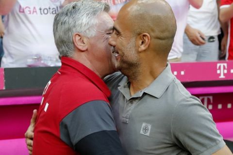 Bayern coach Carlo Ancelotti, left, welcomes Manchester City's coach Pep Guardiola prior to a friendly soccer match between FC Bayern Munich and Manchester City at the Allianz Arena stadium in Munich, Germany, Wednesday, July 20, 2016. (AP Photo/Matthias Schrader)