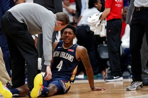 New Orleans Pelicans guard Elfrid Payton (4) is tended to after falling on the court in the second half of an NBA basketball game against the Brooklyn Nets in New Orleans, Friday, Oct. 26, 2018. The Pelicans won 117-115. (AP Photo/Gerald Herbert)