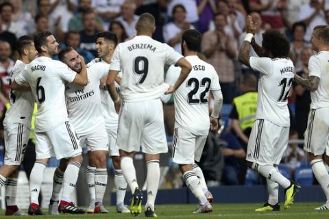 Real Madrid's Daniel Carvajal, center, celebrates with teammates after scoring their side's first goal against Getafe during a Spanish La Liga soccer match at the Santiago Bernabeu stadium in Madrid, Sunday, Aug. 19, 2018. (AP Photo/Andrea Comas)