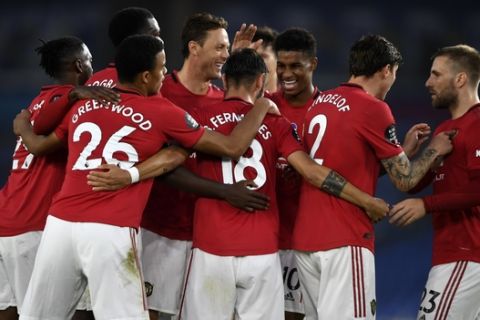 Manchester United players celebrate the second goal of their team during the English Premier League soccer match between Brighton & Hove Albion and Manchester United at the AMEX Stadium in Brighton, England, Tuesday, June 30, 2020. (Mike Hewitt/Pool via AP)