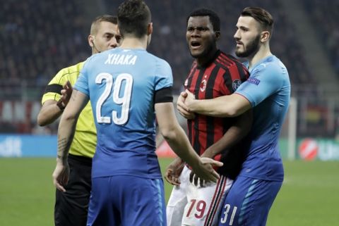 AC Milan's Franck Kessie, second from right, discusses with Arsenal's Granit Xhaka during the Europa League round of 16 first-leg soccer match between AC Milan and Arsenal, at the Milan San Siro Stadium, Italy, Thursday, March 8, 2018. (AP Photo/Luca Bruno)