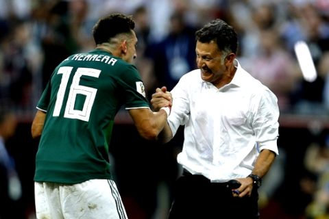 Mexico's Hector Herrera, left, celebrates with Mexico head coach Juan Carlos Osorio, at the end of the group F match between Germany and Mexico at the 2018 soccer World Cup in the Luzhniki Stadium in Moscow, Russia, Sunday, June 17, 2018. Mexico won 1-0. (AP Photo/Victor R. Caivano)