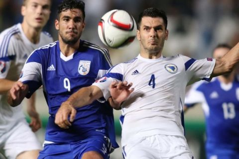 Cyprus' Nestor Mytidis (L) vies with Bosnia and Herzegovina's Emir Spahic after scoring a goal during their Euro 2016 qualifying football match on October 13, 2015 in Nicosia.  AFP PHOTO / NICOS SAVVIDES        (Photo credit should read NICOS SAVVIDES/AFP/Getty Images)