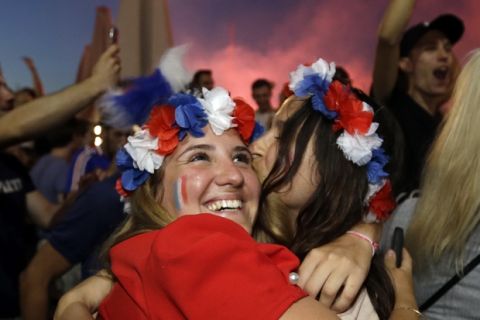 French soccer fans hug each other on the final whistle as they watch a live broadcast of the semifinal match between France and Belgium at the 2018 soccer World Cup, in Marseille, southern France, Tuesday July 10, 2018. France has advanced to the World Cup final for the first time since 2006 with a 1-0 win over Belgium. (AP Photo/Claude Paris)